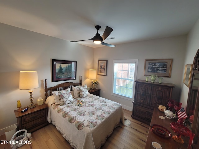 bedroom with visible vents, baseboards, light wood-style flooring, and a ceiling fan