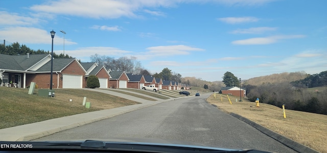 view of road featuring curbs, street lighting, and a residential view