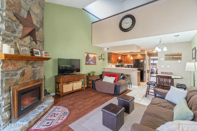 1435 Wiley Oakley Dr Unit 176, Gatlinburg, TN 37738 - living area with a fireplace, high vaulted ceiling, visible vents, a chandelier, and light wood-type flooring