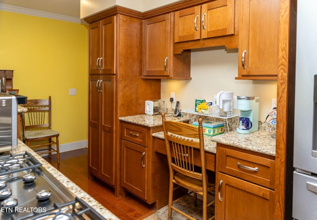 1017 Old Knoxville Hwy, Sevierville, TN 37862 - kitchen with built in desk, dark hardwood / wood-style flooring, light stone countertops, and ornamental molding