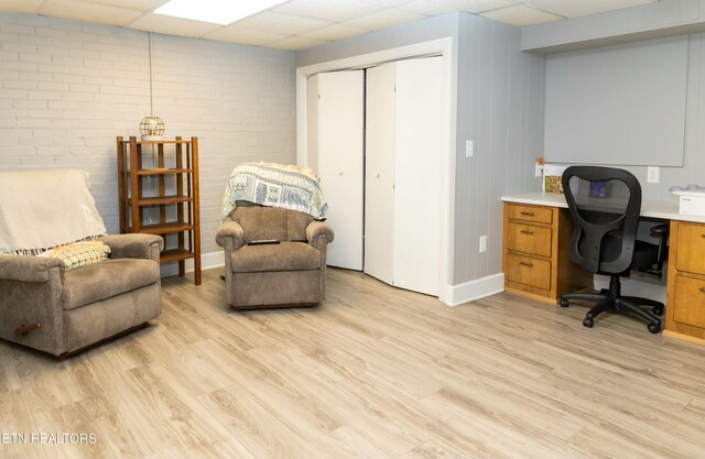 1017 Old Knoxville Hwy, Sevierville, TN 37862 - home office featuring a paneled ceiling, brick wall, and light hardwood / wood-style flooring