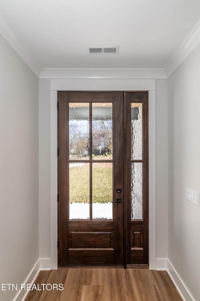 entryway with hardwood / wood-style floors and ornamental molding