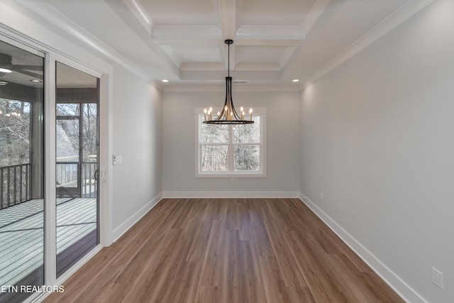 unfurnished dining area with coffered ceiling, an inviting chandelier, hardwood / wood-style flooring, ornamental molding, and beam ceiling