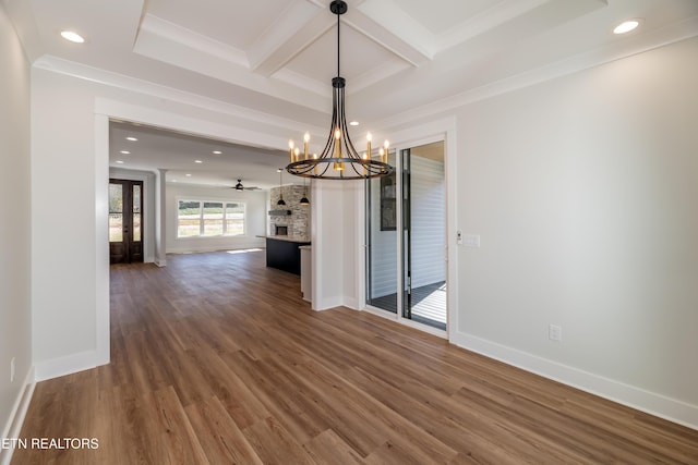 unfurnished dining area with coffered ceiling, wood-type flooring, beamed ceiling, crown molding, and ceiling fan