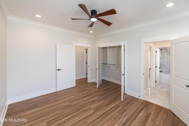 unfurnished bedroom with ceiling fan, ornamental molding, a closet, and hardwood / wood-style floors