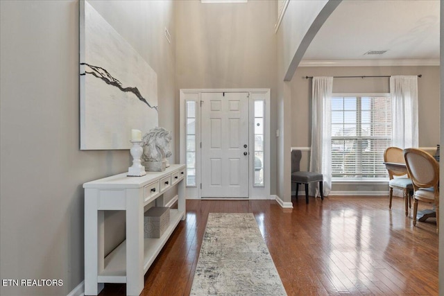 entryway with a high ceiling, ornamental molding, and dark hardwood / wood-style floors