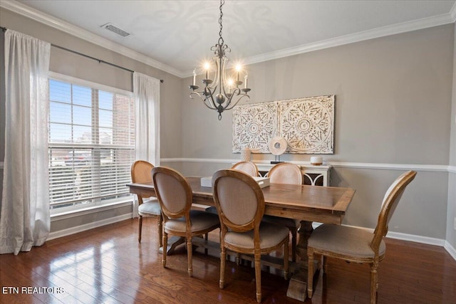 dining space with a chandelier, dark wood-type flooring, visible vents, baseboards, and ornamental molding