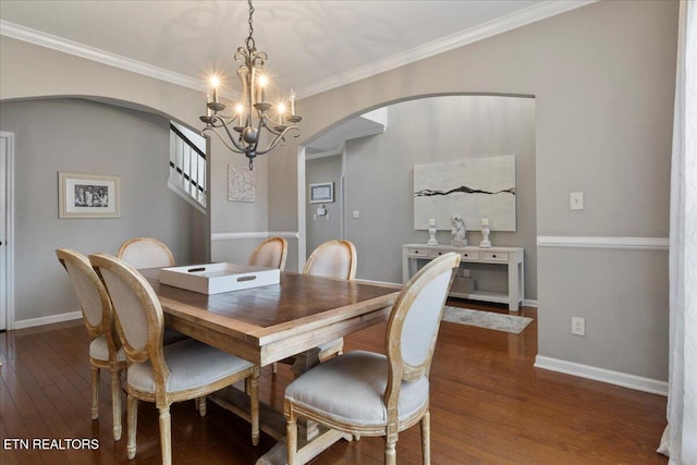 dining area with arched walkways, dark wood-type flooring, ornamental molding, and baseboards