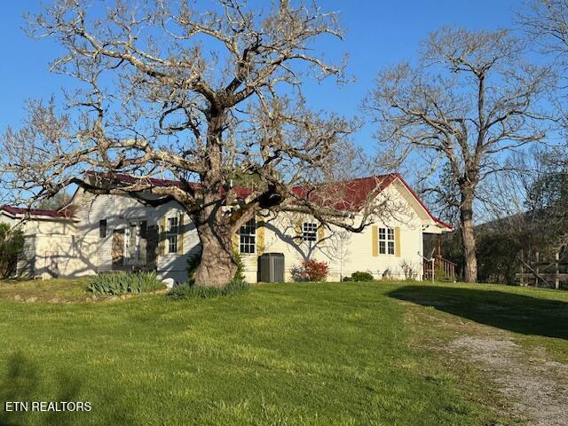 view of property exterior featuring a lawn and central AC