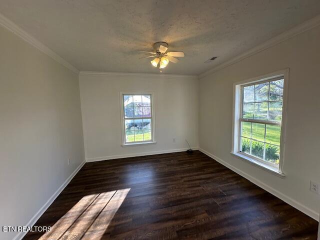 unfurnished room with a ceiling fan, baseboards, dark wood finished floors, and crown molding