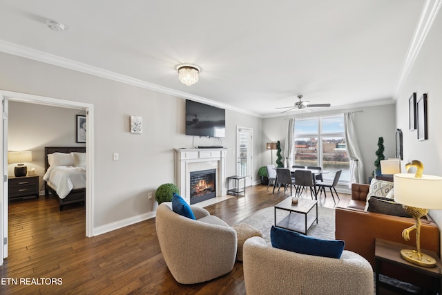 living room with ornamental molding, dark wood-type flooring, and ceiling fan