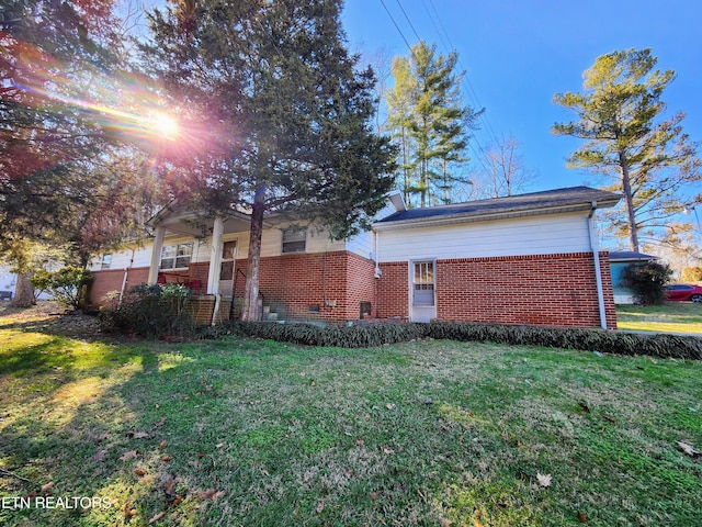 view of property exterior featuring a yard and brick siding