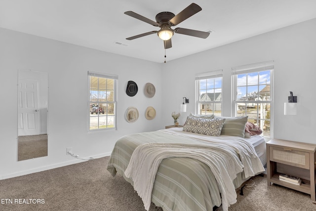 carpeted bedroom with multiple windows and ceiling fan