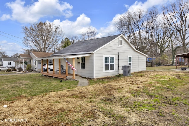 back of house featuring a yard, covered porch, and central AC