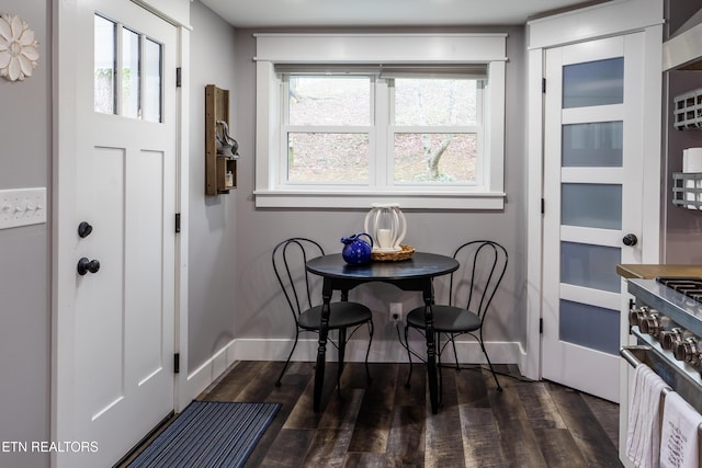 dining area featuring dark wood-type flooring and baseboards