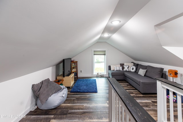 living area featuring dark wood-type flooring, lofted ceiling, and baseboards