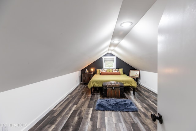 bedroom featuring lofted ceiling, dark wood-style flooring, and baseboards