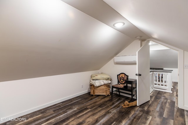 sitting room with lofted ceiling, dark wood-style flooring, an AC wall unit, and baseboards