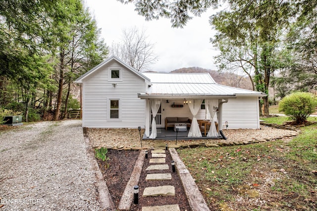 rear view of house with metal roof and a porch