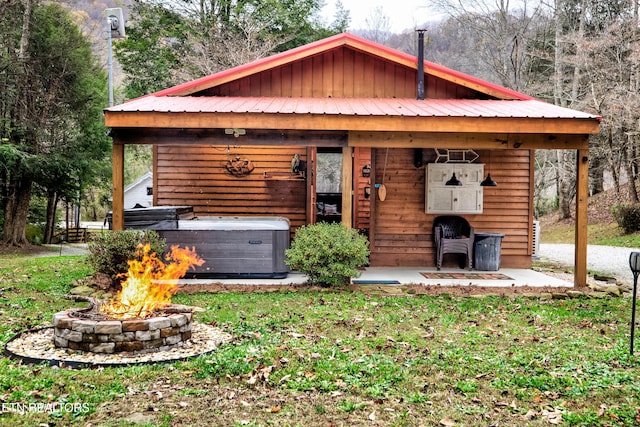 view of front of property with a hot tub, a fire pit, and metal roof