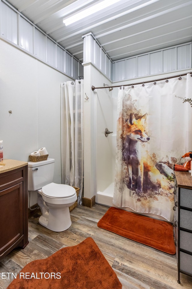 full bathroom with vanity, a shower stall, toilet, and wood finished floors