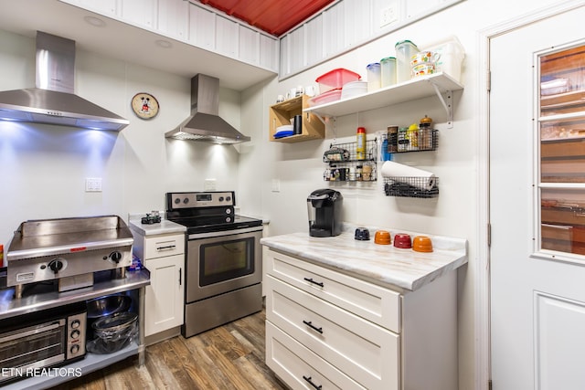 kitchen featuring wall chimney exhaust hood, electric range, light countertops, and white cabinetry