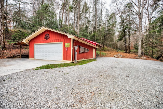 detached garage featuring a view of trees