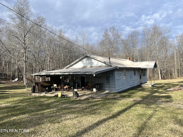 rear view of property featuring a patio and a yard