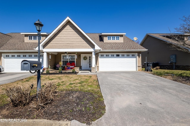 craftsman house with a garage, covered porch, a shingled roof, driveway, and stone siding