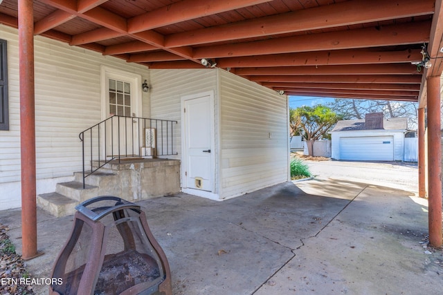 view of patio featuring a garage, an outbuilding, and driveway