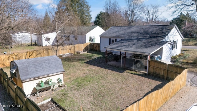 view of yard featuring an outbuilding, a fenced backyard, and a shed