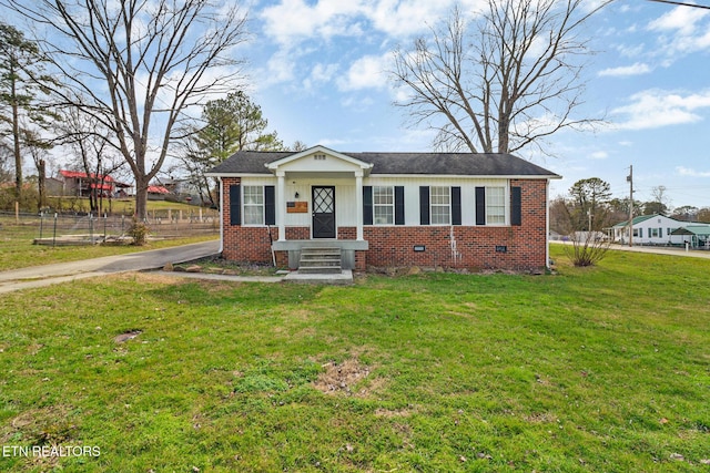 bungalow-style home featuring a shingled roof, crawl space, brick siding, and a front lawn