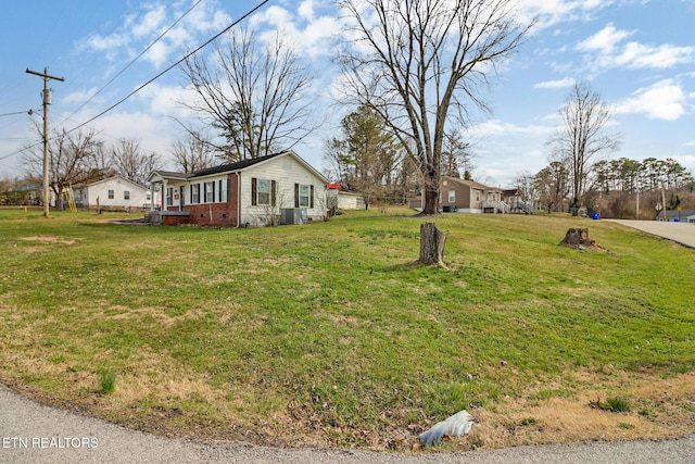 exterior space with crawl space, central AC unit, a lawn, and brick siding