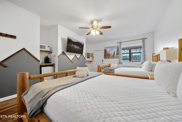 bedroom featuring hardwood / wood-style floors, refrigerator, and ceiling fan