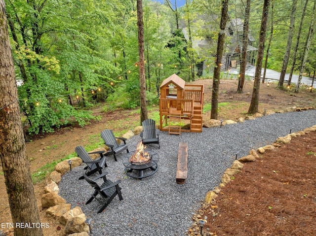 view of yard with an outdoor fire pit and a playground