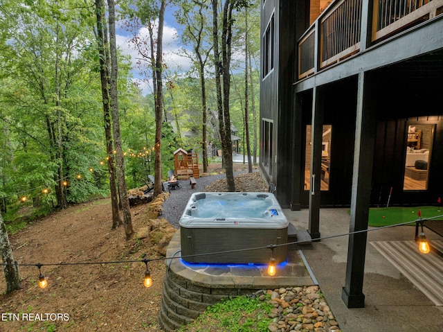 view of yard featuring a hot tub and a balcony