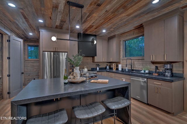 kitchen with dark countertops, gray cabinets, appliances with stainless steel finishes, and pendant lighting