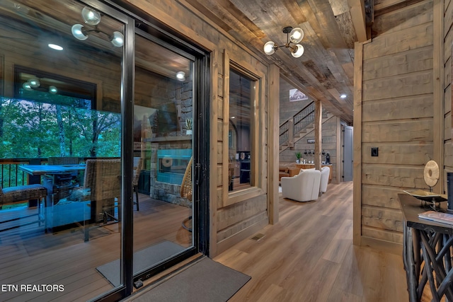 doorway with stairway, wooden ceiling, wood finished floors, and wooden walls