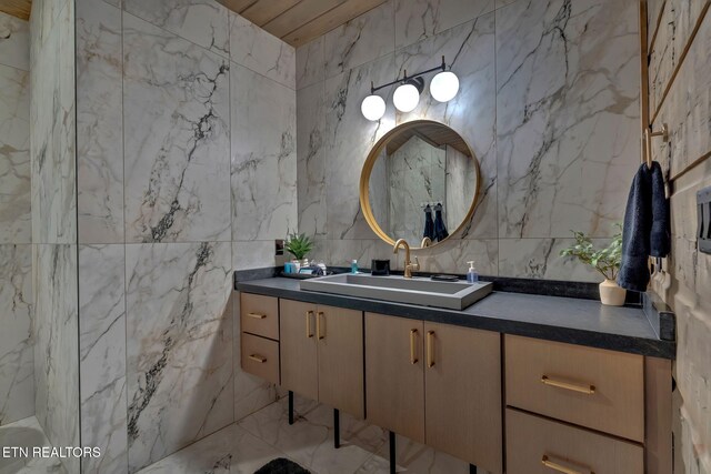 bathroom featuring marble finish floor, vanity, and tile walls