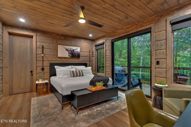 bedroom with wooden ceiling, wooden walls, and wood finished floors