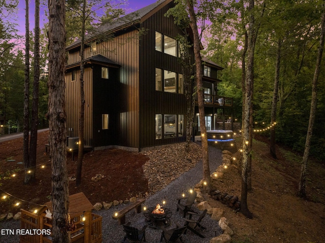 property exterior at dusk featuring a fire pit