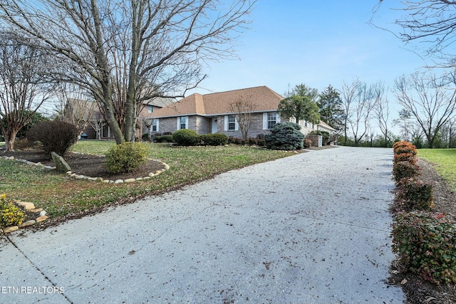 single story home featuring driveway and a front yard