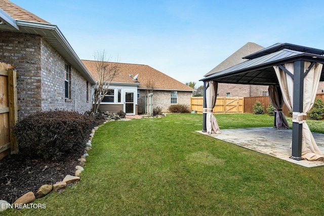 view of yard featuring a patio area, fence, and a gazebo