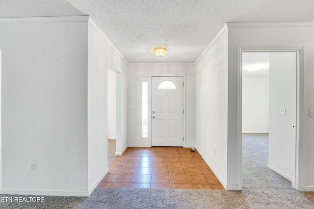 carpeted foyer with a textured ceiling, baseboards, tile patterned flooring, and crown molding