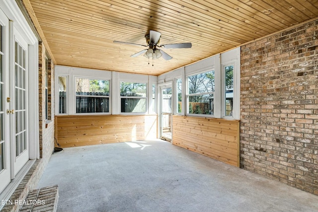 unfurnished sunroom featuring ceiling fan and wood ceiling