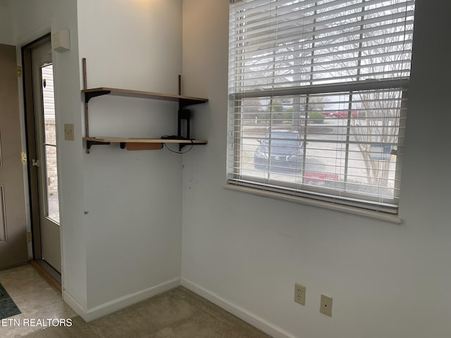 interior space with baseboards and carpet floors