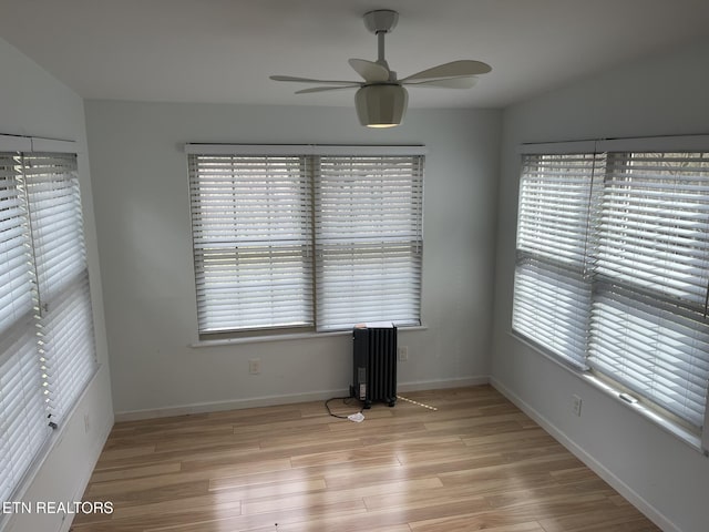 unfurnished room with a healthy amount of sunlight, light wood-style floors, and a ceiling fan