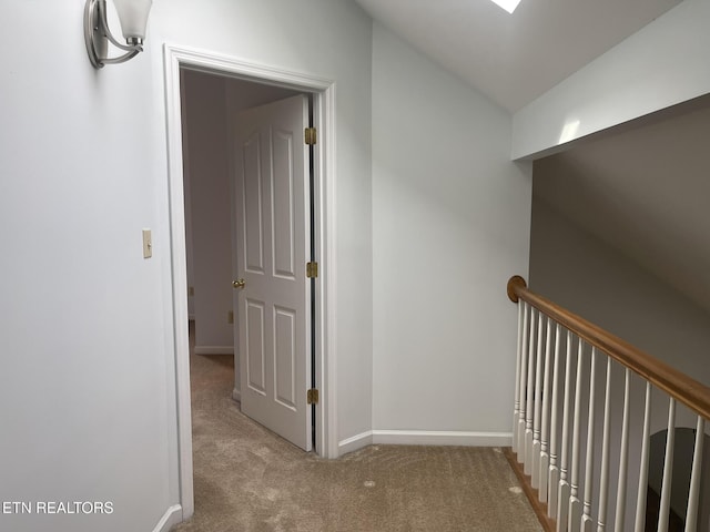 corridor featuring baseboards and carpet