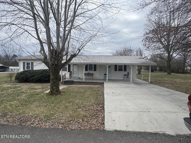 single story home featuring concrete driveway, metal roof, covered porch, a carport, and a front yard