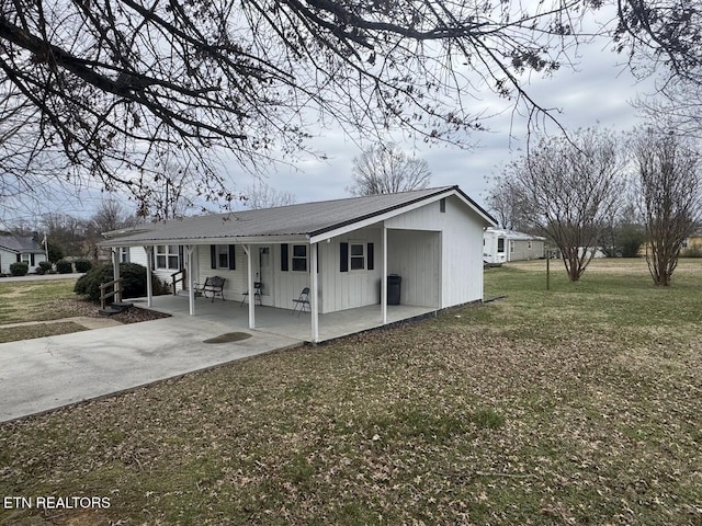 view of front facade featuring metal roof, a front lawn, and concrete driveway